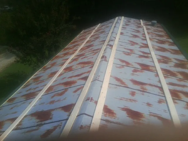 Rusted metal roof panels with new wood purlins before replacement — Storm Damage Roof Repair in Durand by Roofing Brothers