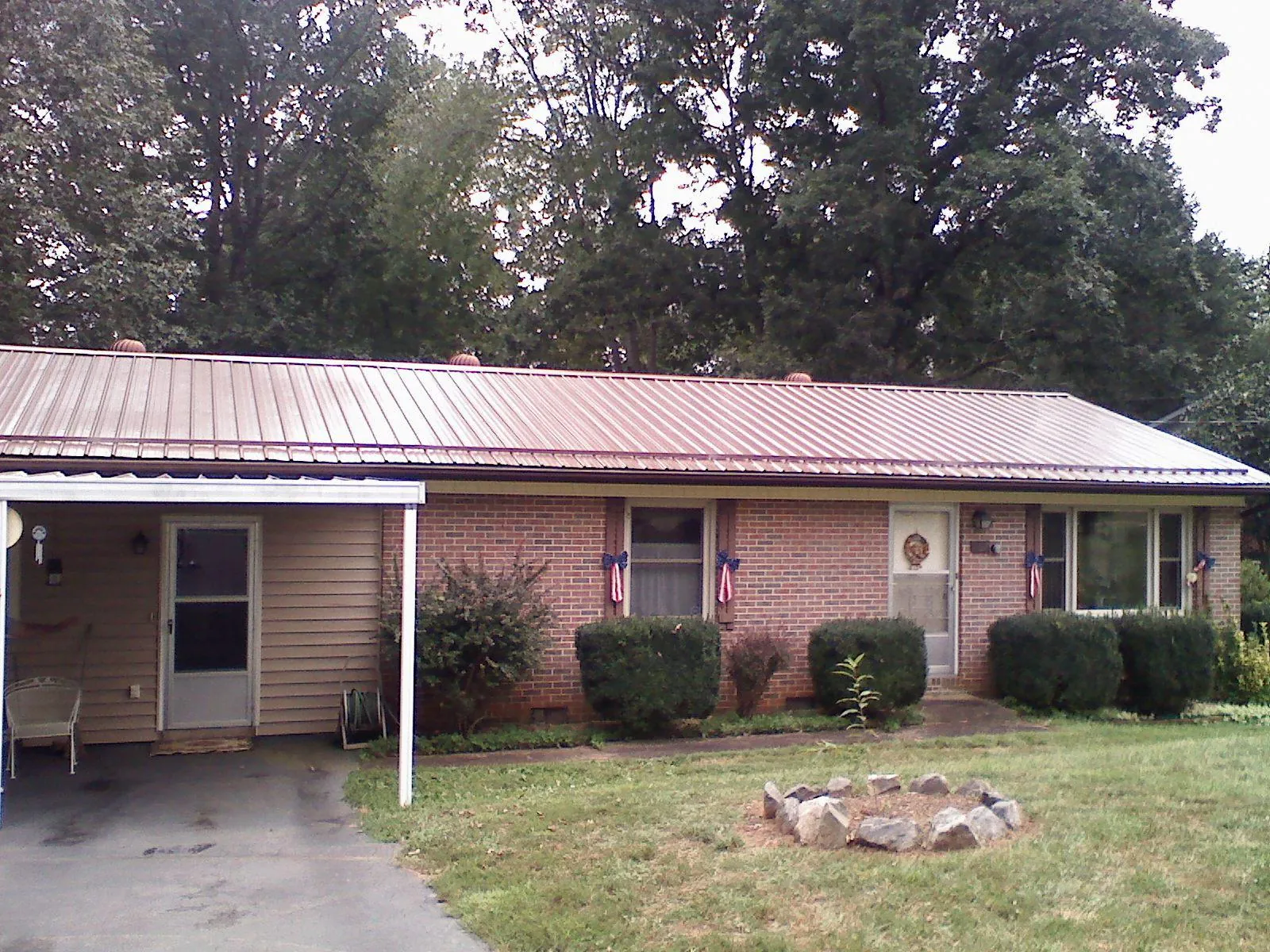 Bronze metal roof and carport on a brick ranch home — Roof Repair work by our crew in Durand