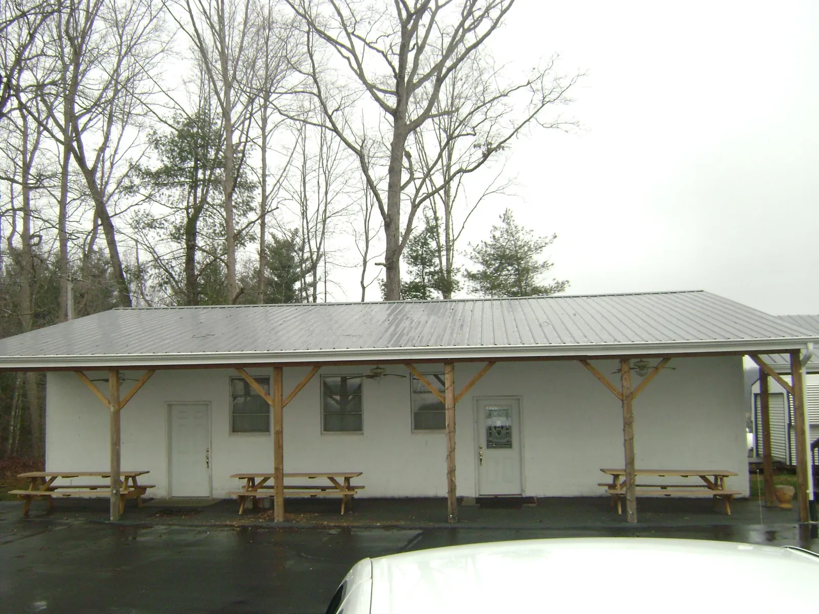 Gray metal roof over a block building with a timber post porch in Durand